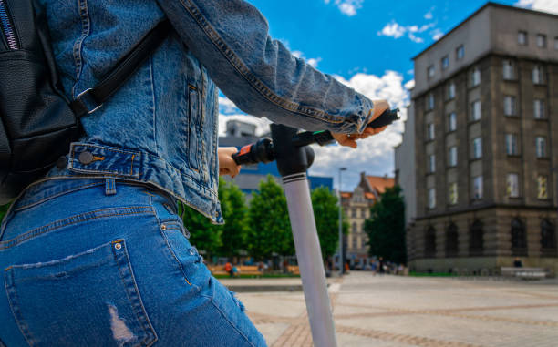 Kick bike. Electric city scooter using from girl. Urban lifestyle background. Eco alternative transport concept. Kick bike. Electric city scooter using from girl. Urban lifestyle background. Eco alternative transport concept lime scooter stock pictures, royalty-free photos & images