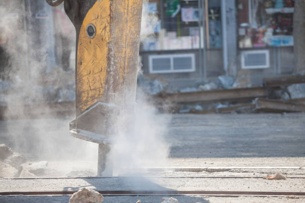 martello pneumatico montato su un veicolo di ristrutturazione, con un trapano pneumatico che perfora l'asfalto di una strada urbana in fase di ristrutturazione in un cantiere stradale. - jackhammer road construction construction worker road foto e immagini stock