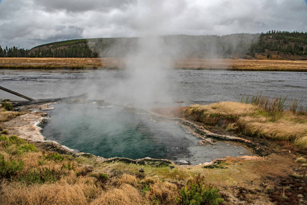 istock A boiling geyser is steaming beside a cold river in Yellowstone. 1257681248