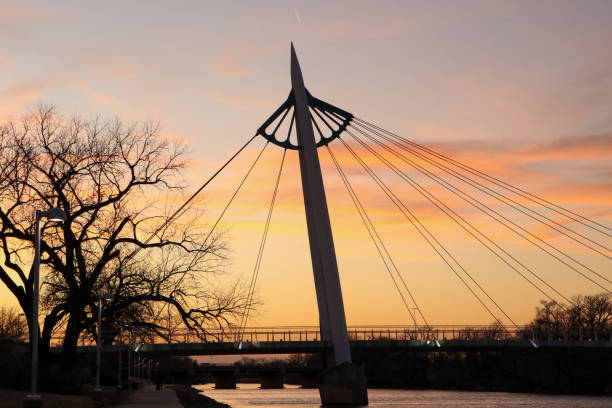 A sunset view of south bridge span of The Keeper of the Plains Bridge A sunset view of south bridge span of The Keeper of the Plains Bridge over the Arkansas River in Wichita, Kansas wichita photos stock pictures, royalty-free photos & images