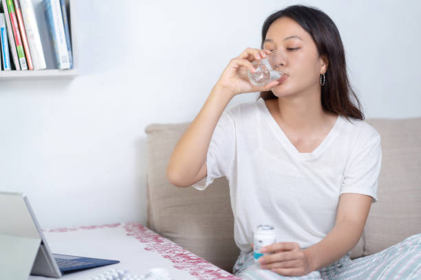 istock Asian woman Currently taking medicine While working at a computer desk, she is working home. 1257684290