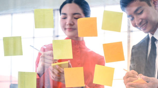istock Business couple   meeting at office and use post it notes to share idea. 1257688311