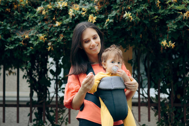 istock Mother Walking Baby Outdoors in Baby Wearing System 1257689935