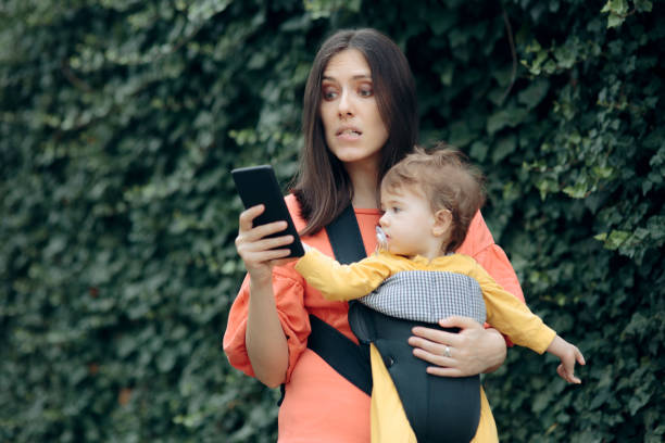 istock Stressed Mother Holding Smartphone Walking Baby 1257689940
