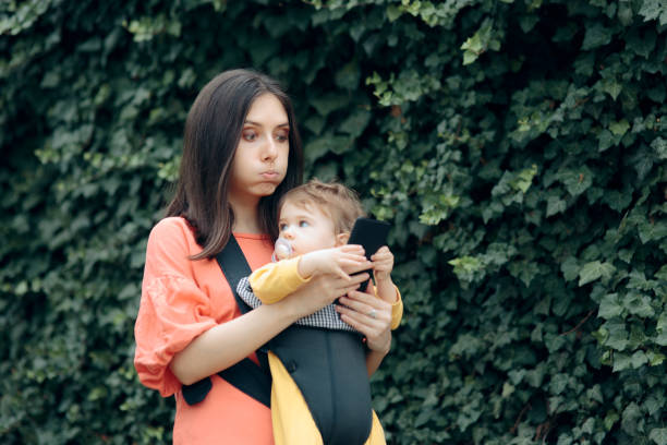 istock Stressed Mother Holding Smartphone Walking Baby 1257689943