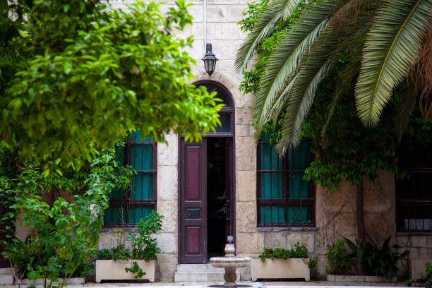 Damascus, Syria 03/28/2010: An old house called Maktab Anbar which was built in the famous  Damascene style in 19th century. Image was taken from the courtyard featuring a door, trees and a fountain.