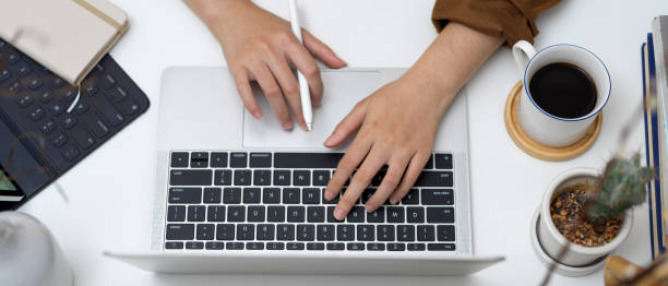istock Female hands using laptop with digital tablet, supplies and decorations on white table 1257690953