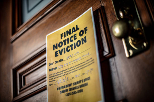 Notice of Eviction docuement on door of house Eviction notice on door of house with brass door knob. Fictitious address, ID, signature and 555 phone number for fictional usage. eviction photos stock pictures, royalty-free photos & images