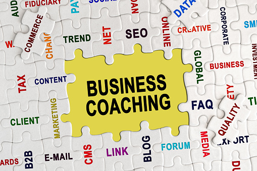 Economy and business concept. Puzzle with economic captions, in the center the inscription - BUSINESS COACHING