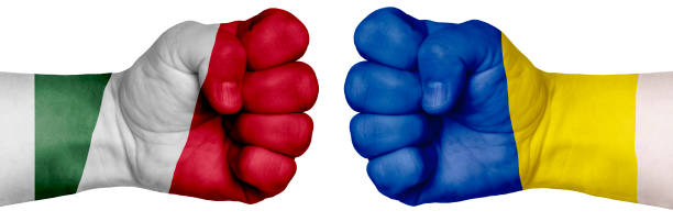 istock Two hands are clenched into fists and are located opposite each other. Hands painted in the colors of the flags of the countries. Hungary vs Ukraine 1257698564