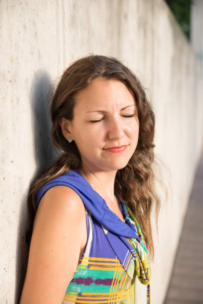 istock Young woman smiling with eyes closed on a sunny day 1257699478