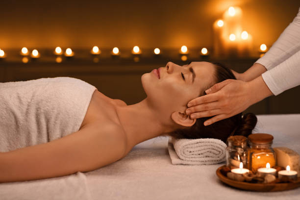 istock Relaxed young woman getting head massage at romantic spa atmosphere 1257703131