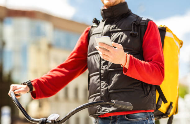 istock Courier Man With Cellphone Delivering Food On Bicycle Outdoors, Cropped 1257703343