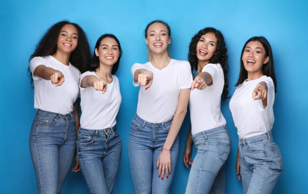 istock Multiethnic Girls Pointing Finger At Camera Over Blue Background, Studio 1257703979