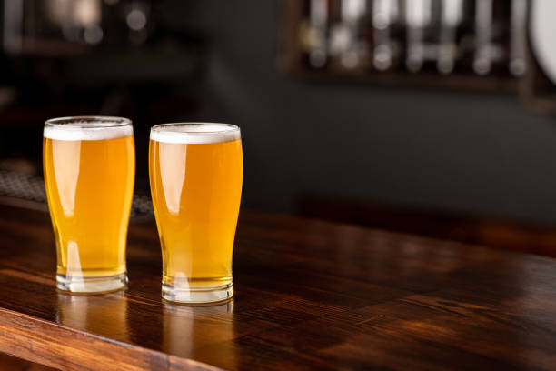istock Patrick day in pub. Two glasses of beer with foam on bar counter 1257703985