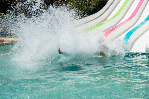 child sliding down a water slide in a water park