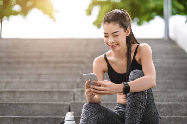 istock Fitness App. Sporty Asian Girl Using Smartphone Checking Her Progress After Training 1257705492