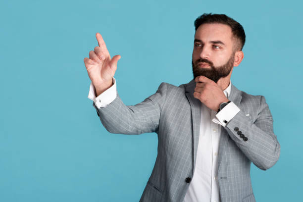 istock Office worker in formal suit selecting something on transparent screen over blue background, free space 1257705702