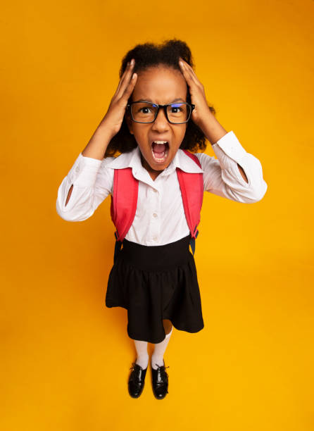 istock Stressed Black Schoolgirl Shouting Touching Head In Studio, Vertical Shot 1257706485