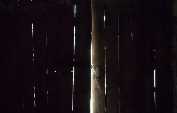 istock Old wooden double-leaf ominous barn doors, through the doors rays of sunlight break through. The concept of spiritual development and the path to light from darkness 1257706680