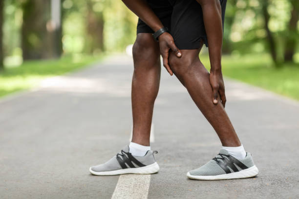 istock African guy rubbing his aching leg, got cramp while jogging 1257707512