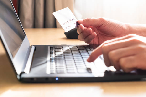 istock Selective focus at men hand holding credit card mock up while type payment information on laptop for online purchase from home during Coronavirus pandemic. Technology and Social distance concept. 1257709249