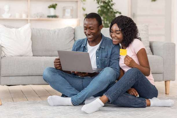 istock Cheerful black couple shopping online, home interior 1257709253
