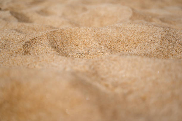 istock Close up of sand shore with blurred sea background. 1257710551