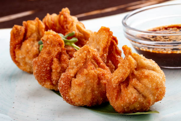 istock Fried wontons with soy sauce served on a bamboo leaf. 1257711822