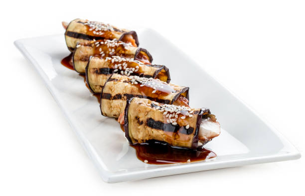 istock Eggplant rolls stuffed with Philadelphia cheese and eel. On white background. 1257712074
