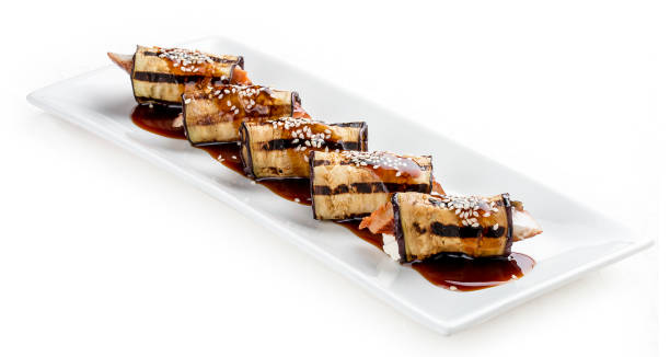 istock Eggplant rolls stuffed with Philadelphia cheese and eel. On white background. 1257712075