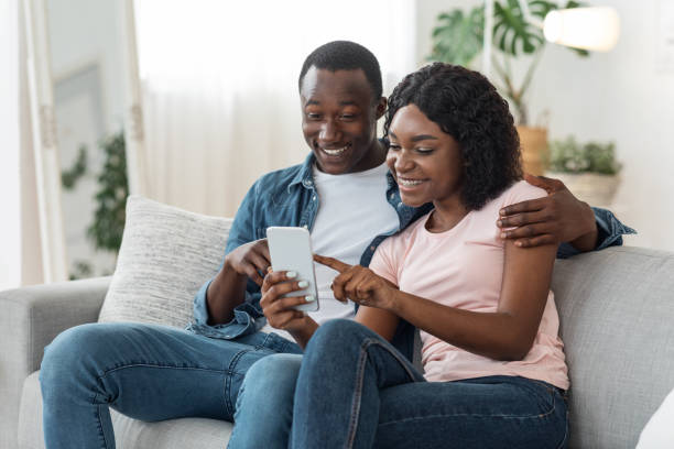 istock Excited black couple checking new mobile app, home interior 1257712917