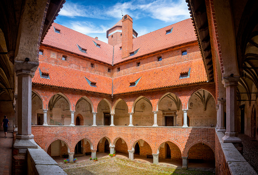 Lidzbark Warminski, Poland - July 01, 2020:The courtyard of the Lidzbark Bishops' Castle with characteristic galleries. The gothic fortified castle was built between 1350-1401 as the seat of the Warmian bishops, later going into the hands of the Teutonic Order. The castle is located in the town of Lidzbark Warmiński, Warmian-Masurian Voivodeship, Poland.