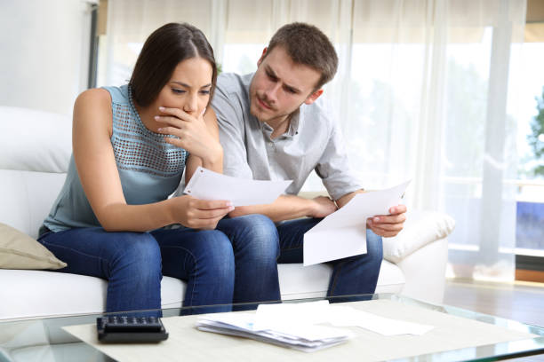 istock Worried couple checking receipt sitting at home 1257713600