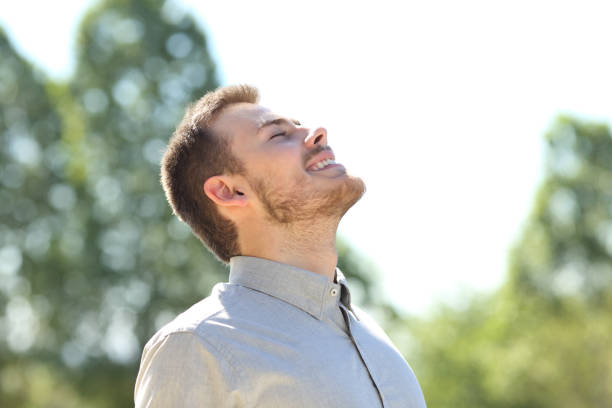 istock Happy man breathing fresh air standing on a park 1257713678