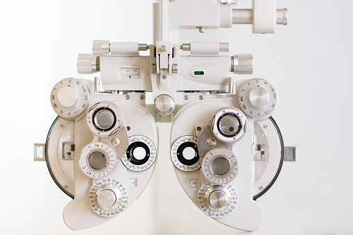 Phoropter close up view of ophthalmology, optometry, and optician clinical testing machine equipment against a white background