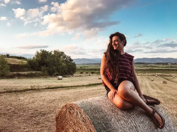 woman sitting on the haybales