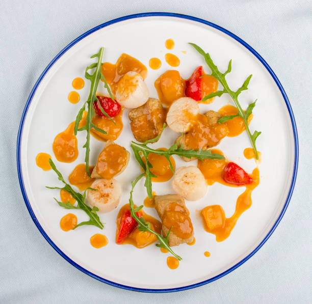 istock Scallop with strawberries and arugula. On white background 1257713901