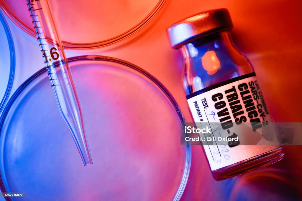 Covid-19 Clinical Trials: vials and petri dishes on white table vials and petri dishes on white table  for clinical trials of covid-19 Vaccination Stock Photo