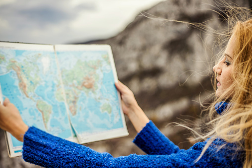 Woman traveler checks map to find directions in wilderness area