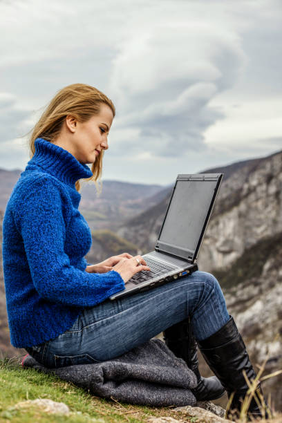 istock Young hiker using her laptop while sitting on top of a mountain 1257717466