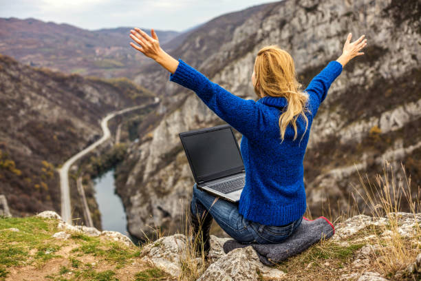 istock Young hiker using her laptop while sitting on top of a mountain 1257717476