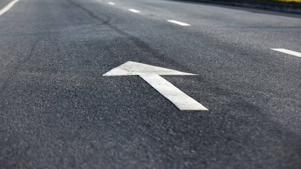 istock Close ups white arrow on asphalt road surface 1257718165