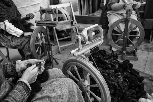 Spinning with a wooden spinning wheel, handicraft detail, thread manufacturing