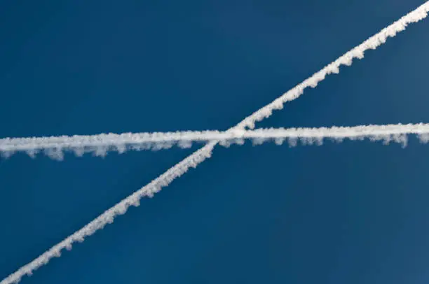 Condensation Trails crossing, Chemtrail against the blue sky. Nikon D850. Converted from RAW.