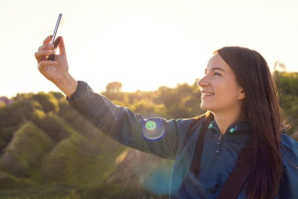 istock Attractive young woman taking selfie sunset background 1257721578
