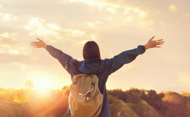 istock Freedom concept Woman with backpack and hands outstretched enjoying the sunset 1257721586