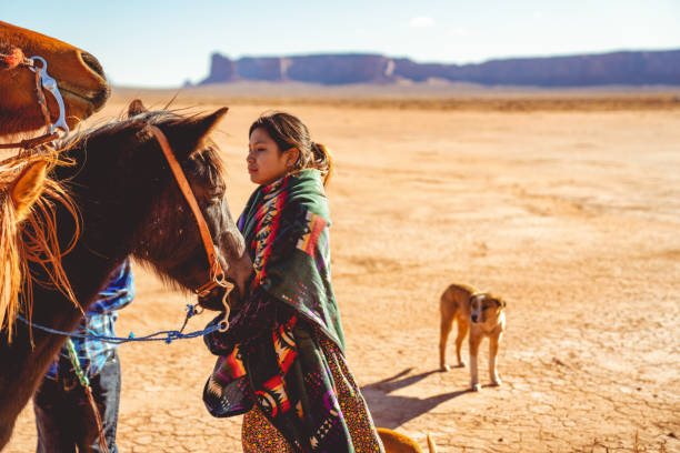 young teenage navajo girl on a horse in the beautiful desert of monument valley arizona - saddle blanket imagens e fotografias de stock