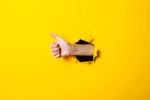 istock Male hand showing thumb up gesture, everything is ok, class on yellow background. 1257721898