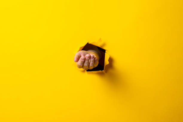 istock Opened male hand, palm up on a yellow background. Sign language 1257721904